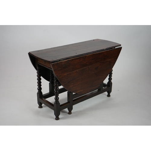 66 - A 17th century and later oak gateleg table with oval drop leaf top and single frieze drawer, on bobb... 