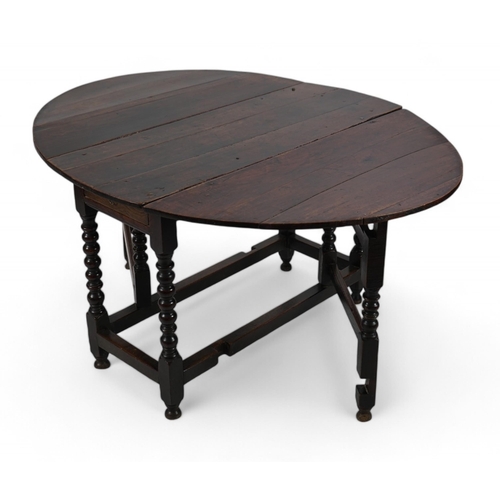 66 - A 17th century and later oak gateleg table with oval drop leaf top and single frieze drawer, on bobb... 