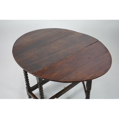 66 - A 17th century and later oak gateleg table with oval drop leaf top and single frieze drawer, on bobb... 