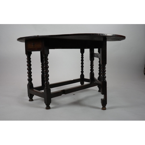 66 - A 17th century and later oak gateleg table with oval drop leaf top and single frieze drawer, on bobb... 