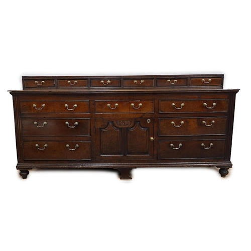 9 - A George III oak dresser base, the raised back with six crossbanded drawers over three frieze drawer... 