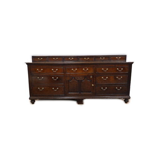 9 - A George III oak dresser base, the raised back with six crossbanded drawers over three frieze drawer... 