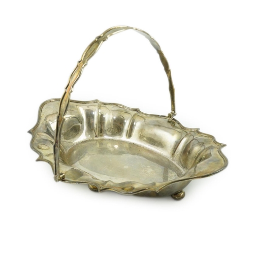 104 - An Edwardian silver cake basket, by William Comyns & Sons Ltd, of shaped oval form, on four ball fee... 