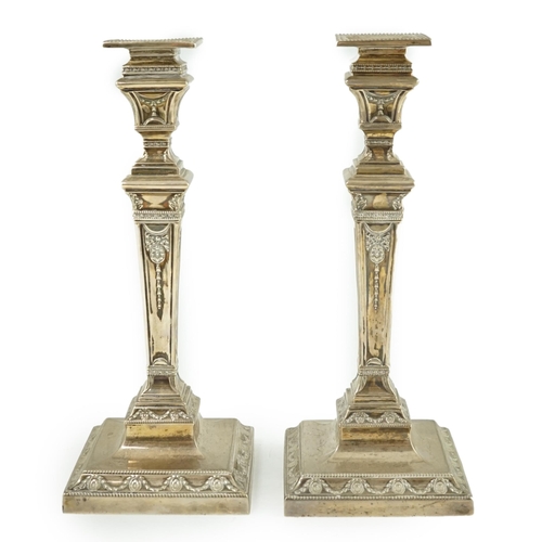 106 - A pair of Edwardian Adam revival silver candlesticks, by Walker & Hall, with beaded borders, on squa... 