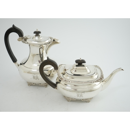 134 - A George V silver hot water pot and matching teapot, by Reid & Sons, of oval form, with winged paw f... 