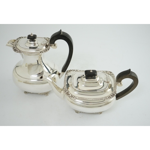 134 - A George V silver hot water pot and matching teapot, by Reid & Sons, of oval form, with winged paw f... 