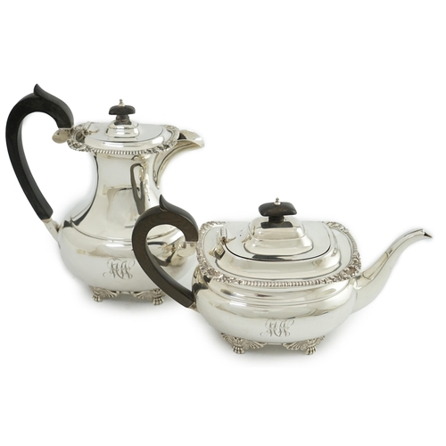 134 - A George V silver hot water pot and matching teapot, by Reid & Sons, of oval form, with winged paw f... 