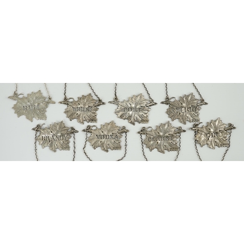 137 - A set of eight Elizabeth II silver leaf wine labels, maker SMD, pierced with the names of different ... 