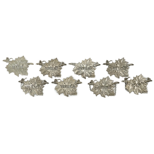 137 - A set of eight Elizabeth II silver leaf wine labels, maker SMD, pierced with the names of different ... 