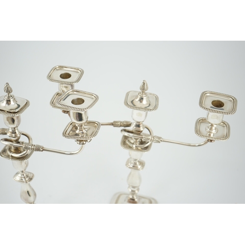 143 - A pair of Elizabeth II silver two branch two light candelabra, by James Dixon & Sons, with scroll ar... 