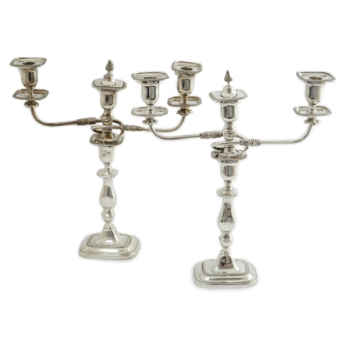 143 - A pair of Elizabeth II silver two branch two light candelabra, by James Dixon & Sons, with scroll ar... 