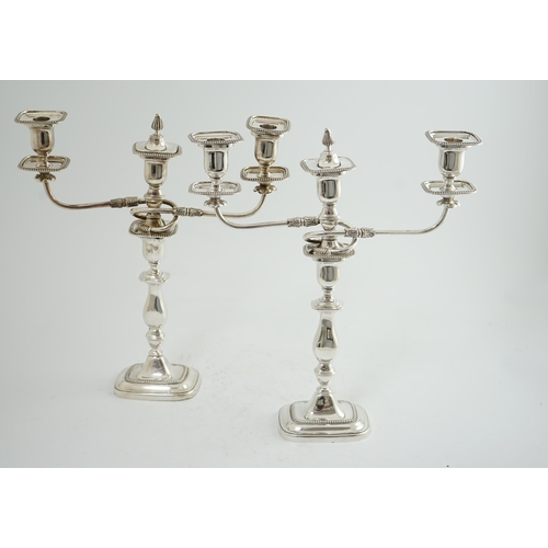 143 - A pair of Elizabeth II silver two branch two light candelabra, by James Dixon & Sons, with scroll ar... 