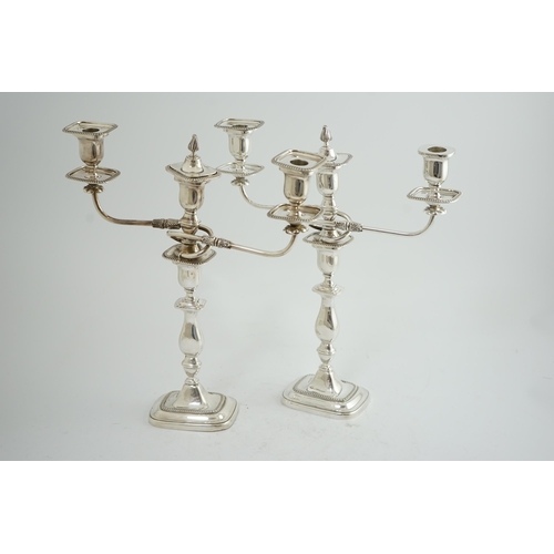 143 - A pair of Elizabeth II silver two branch two light candelabra, by James Dixon & Sons, with scroll ar... 