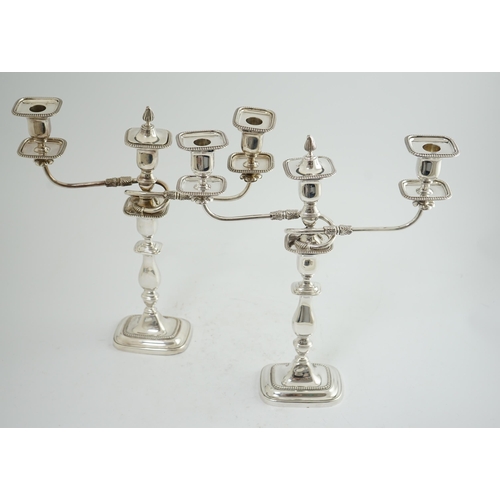 143 - A pair of Elizabeth II silver two branch two light candelabra, by James Dixon & Sons, with scroll ar... 