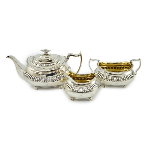 19A - A George III silver three piece tea set, by Soloman Hougham, of oval form, with fluted band, engrave... 