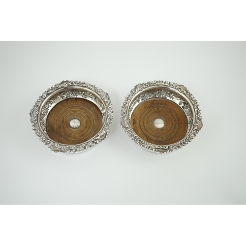 41 - A pair of George IV silver wine coasters, by S.C. Younge & Co, embossed with fruiting vine decoratio... 