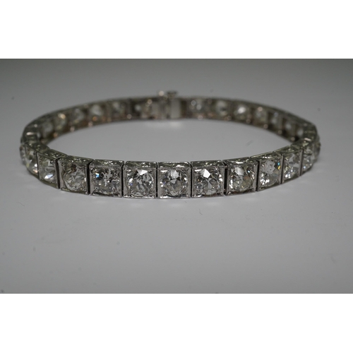 479 - A platinum and thirty one stone round cut diamond set line bracelet, with carved setting, the total ... 