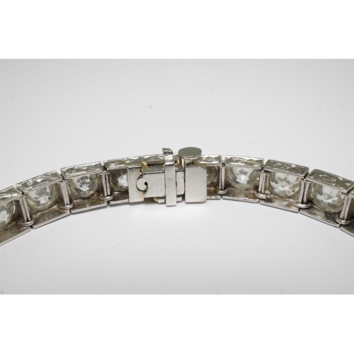 479 - A platinum and thirty one stone round cut diamond set line bracelet, with carved setting, the total ... 