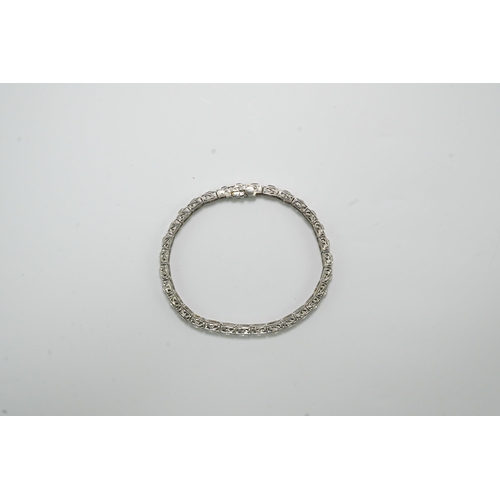 479 - A platinum and thirty one stone round cut diamond set line bracelet, with carved setting, the total ... 