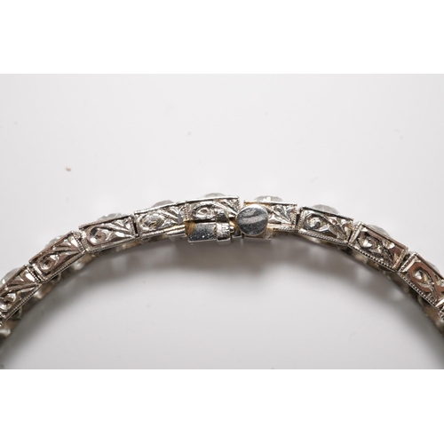 479 - A platinum and thirty one stone round cut diamond set line bracelet, with carved setting, the total ... 