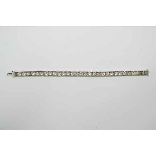 479 - A platinum and thirty one stone round cut diamond set line bracelet, with carved setting, the total ... 