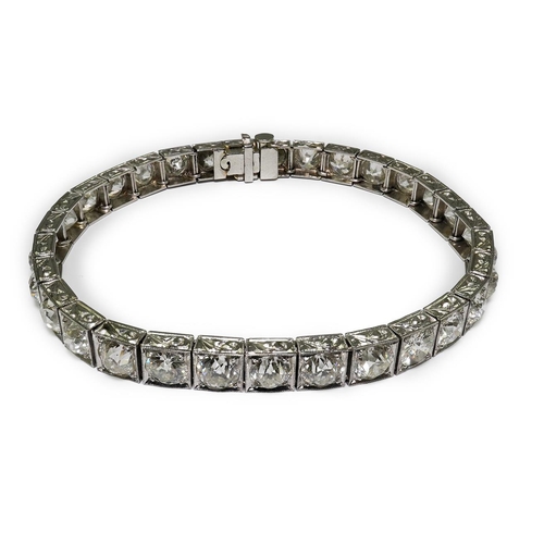 479 - A platinum and thirty one stone round cut diamond set line bracelet, with carved setting, the total ... 