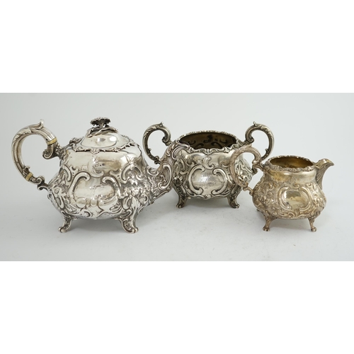 64 - A matched Victorian and later silver three piece tea set, with embossed scroll decoration, teapot an... 