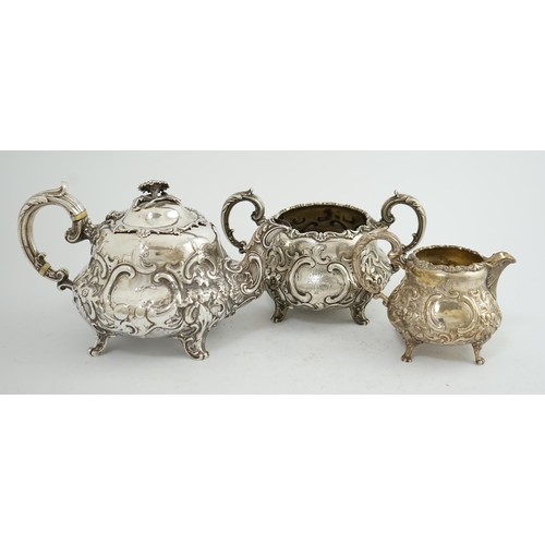 64 - A matched Victorian and later silver three piece tea set, with embossed scroll decoration, teapot an... 