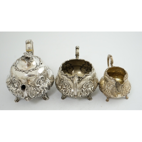 64 - A matched Victorian and later silver three piece tea set, with embossed scroll decoration, teapot an... 