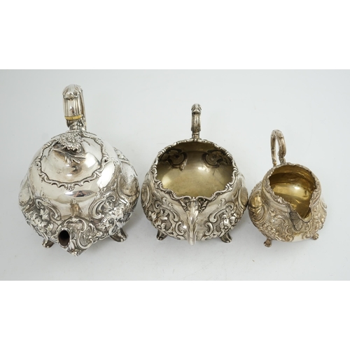 64 - A matched Victorian and later silver three piece tea set, with embossed scroll decoration, teapot an... 