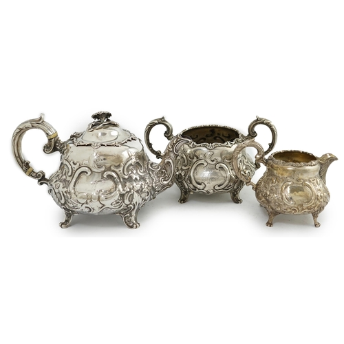 64 - A matched Victorian and later silver three piece tea set, with embossed scroll decoration, teapot an... 