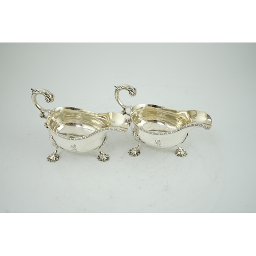 7 - A pair of George III silver sauceboats, by Thomas Evans, with flying scroll handles and engraved arm... 