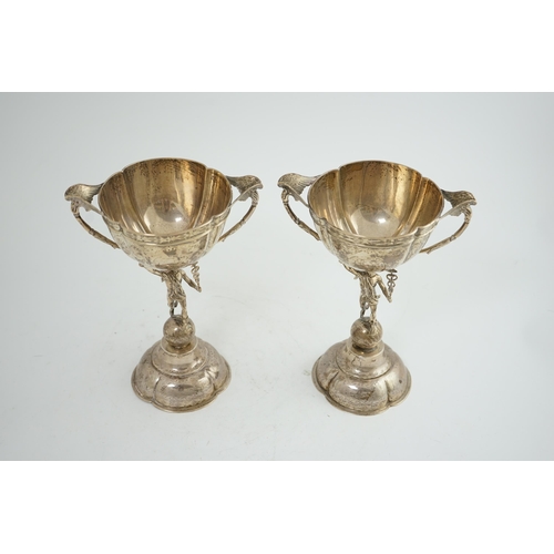 88 - A pair of Victorian silver two handled pedestal cups, each figural stem modelled as Hermes upon a gl... 