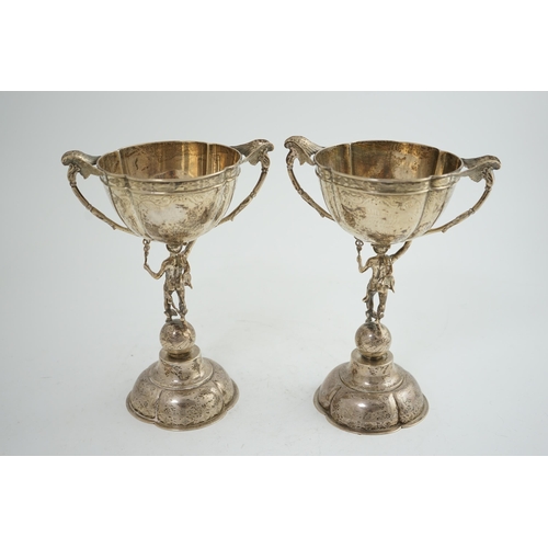 88 - A pair of Victorian silver two handled pedestal cups, each figural stem modelled as Hermes upon a gl... 