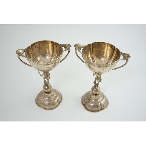 88 - A pair of Victorian silver two handled pedestal cups, each figural stem modelled as Hermes upon a gl... 