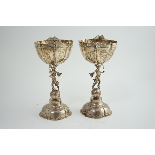 88 - A pair of Victorian silver two handled pedestal cups, each figural stem modelled as Hermes upon a gl... 