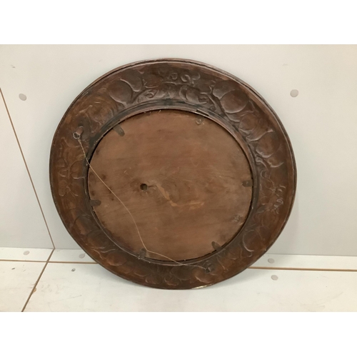 1113 - An Arts & Crafts circular embossed copper wall mirror, diameter 54cm. Condition - fair