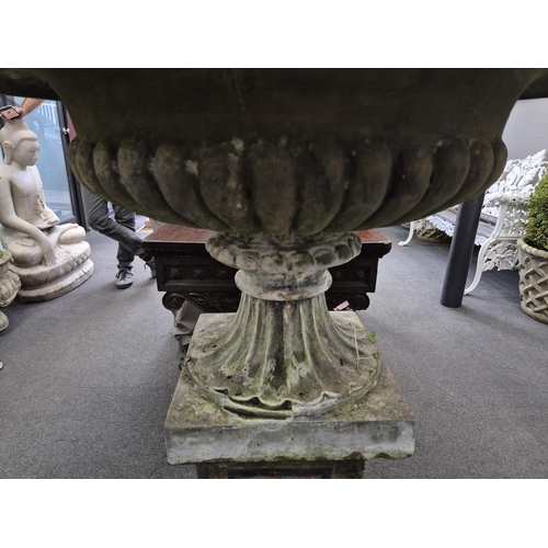 15 - A large reconstituted stone garden vase with fluted sides, on square plinth, 80cm diameter, 116cm hi... 