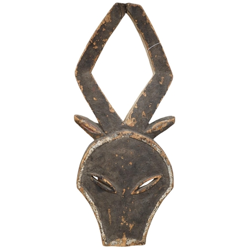 2211 - A Kwele painted wood mask in the form of an antelopes head, 68cm high. Condition - fair, some paint... 