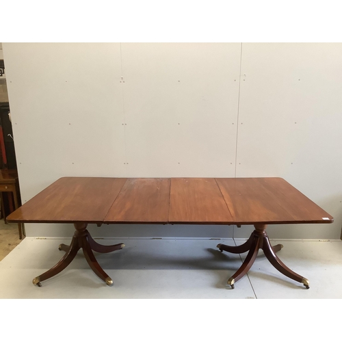 21 - A Regency mahogany twin pillar extending dining table, width approximately 240cm extended, two spare... 