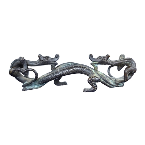 409 - A Chinese bronze brush rest modelled as two dragons, 17cm wide. Condition - good