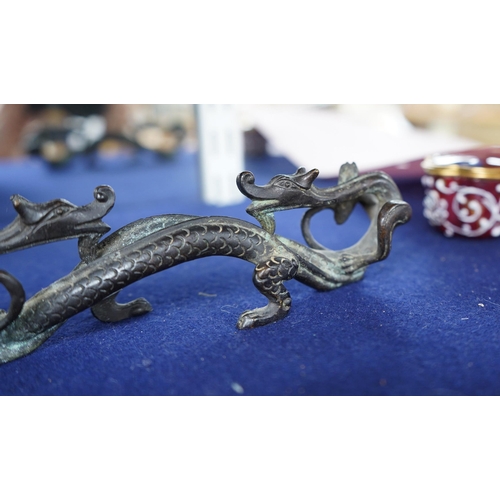 409 - A Chinese bronze brush rest modelled as two dragons, 17cm wide. Condition - good