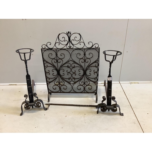 1098 - A pair of wrought iron fire dogs, with brazier finials, height 71cm, a wrought iron and wire mesh sp... 