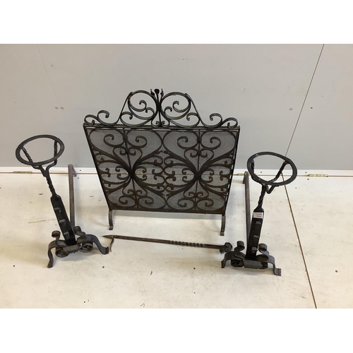 1098 - A pair of wrought iron fire dogs, with brazier finials, height 71cm, a wrought iron and wire mesh sp... 