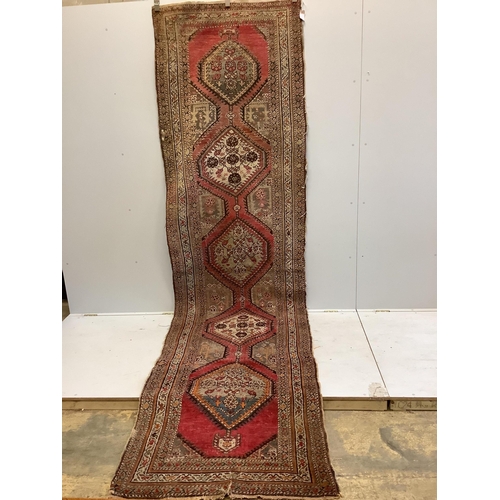 1105 - A Caucasian red ground runner, woven with a row of octagons, 416 x 106cm. Condition - fair