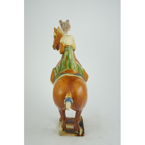 103 - A Chinese sancai glazed group of a horse and female rider, Tang or later, decorated in ochre green a... 