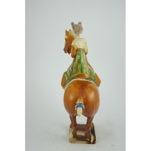 103 - A Chinese sancai glazed group of a horse and female rider, Tang or later, decorated in ochre green a... 