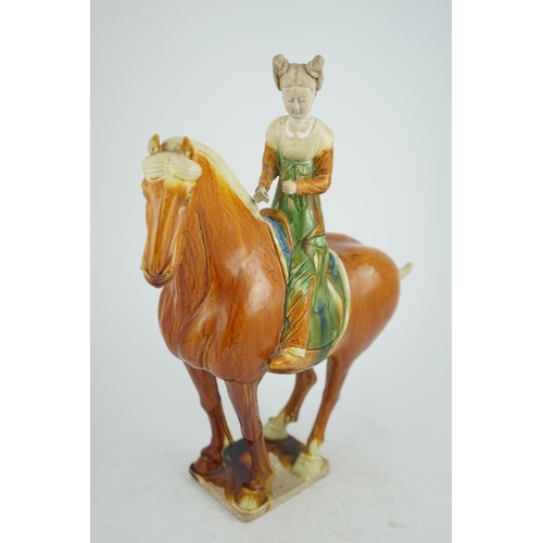 103 - A Chinese sancai glazed group of a horse and female rider, Tang or later, decorated in ochre green a... 