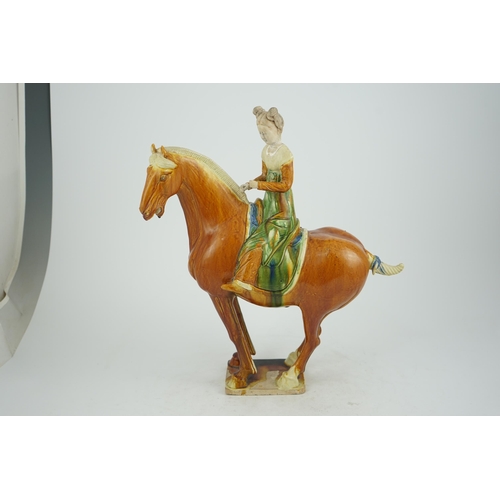 103 - A Chinese sancai glazed group of a horse and female rider, Tang or later, decorated in ochre green a... 