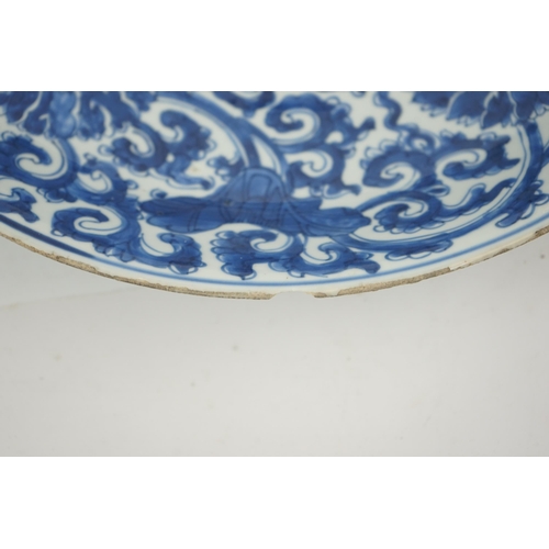 120 - A large Chinese blue and white lotus dish, Kangxi period, painted with five lotus flowers, scrolli... 